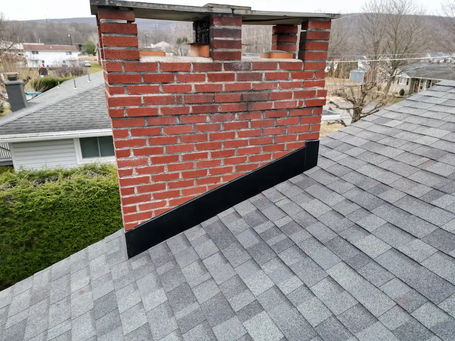 Roof flashing around a masonry chimney on an asphalt shingle roof in Olyphant Pennsylvania