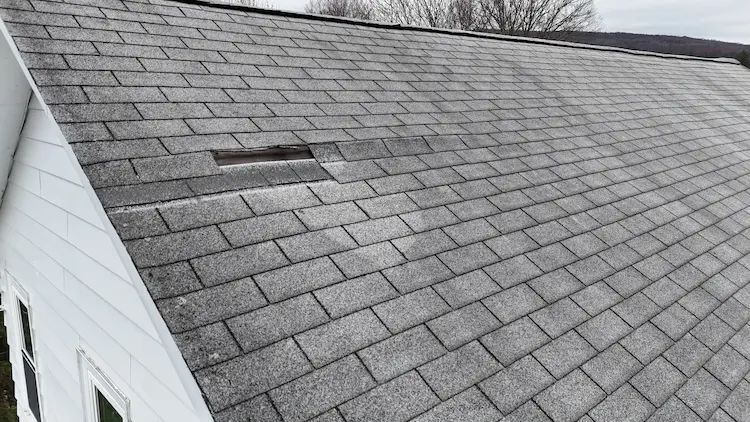 Aging and damaged asphalt shingles on a residential roof in Jermyn Pennsylvania.